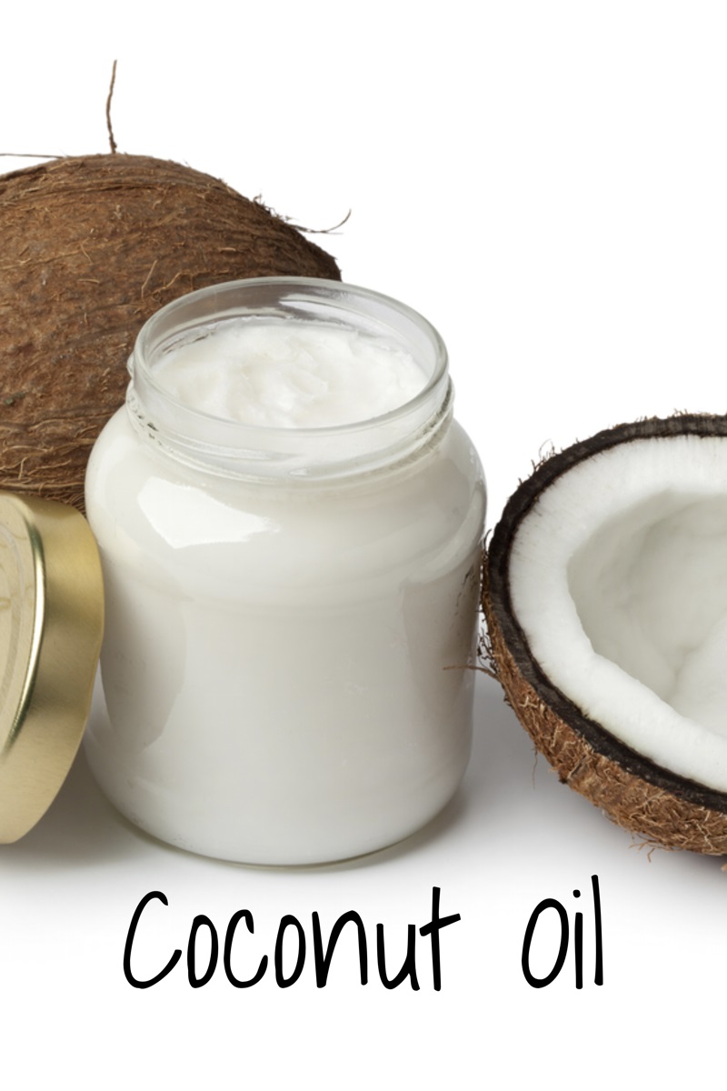 jar of coconut oil with two coconuts next to it