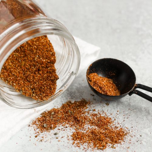 side view of taco seasoning being poured from a mason jar