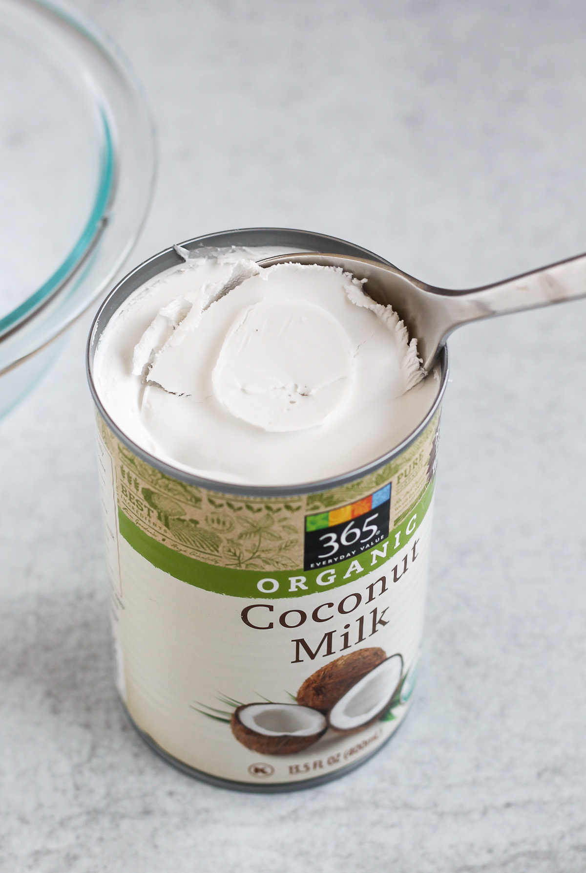 close up coconut milk can with the coconut cream being scooped out