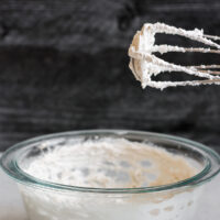 electric beater with whipped coconut cream standing over mixing bowl