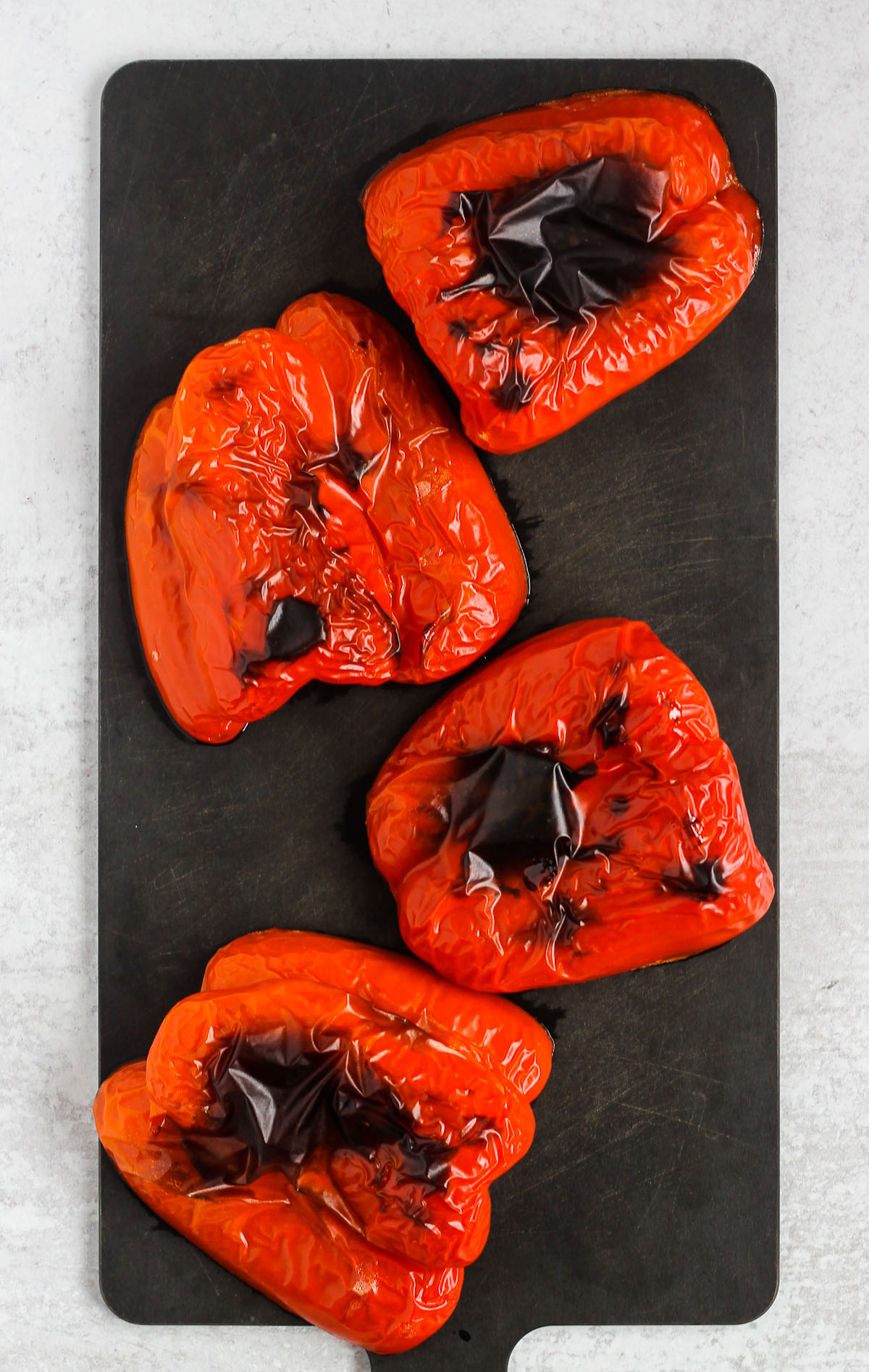 roasted red pepper halves on black cutting board