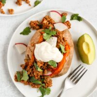 overhead view of stuffed sweet potato topped with cilantro and sour cream