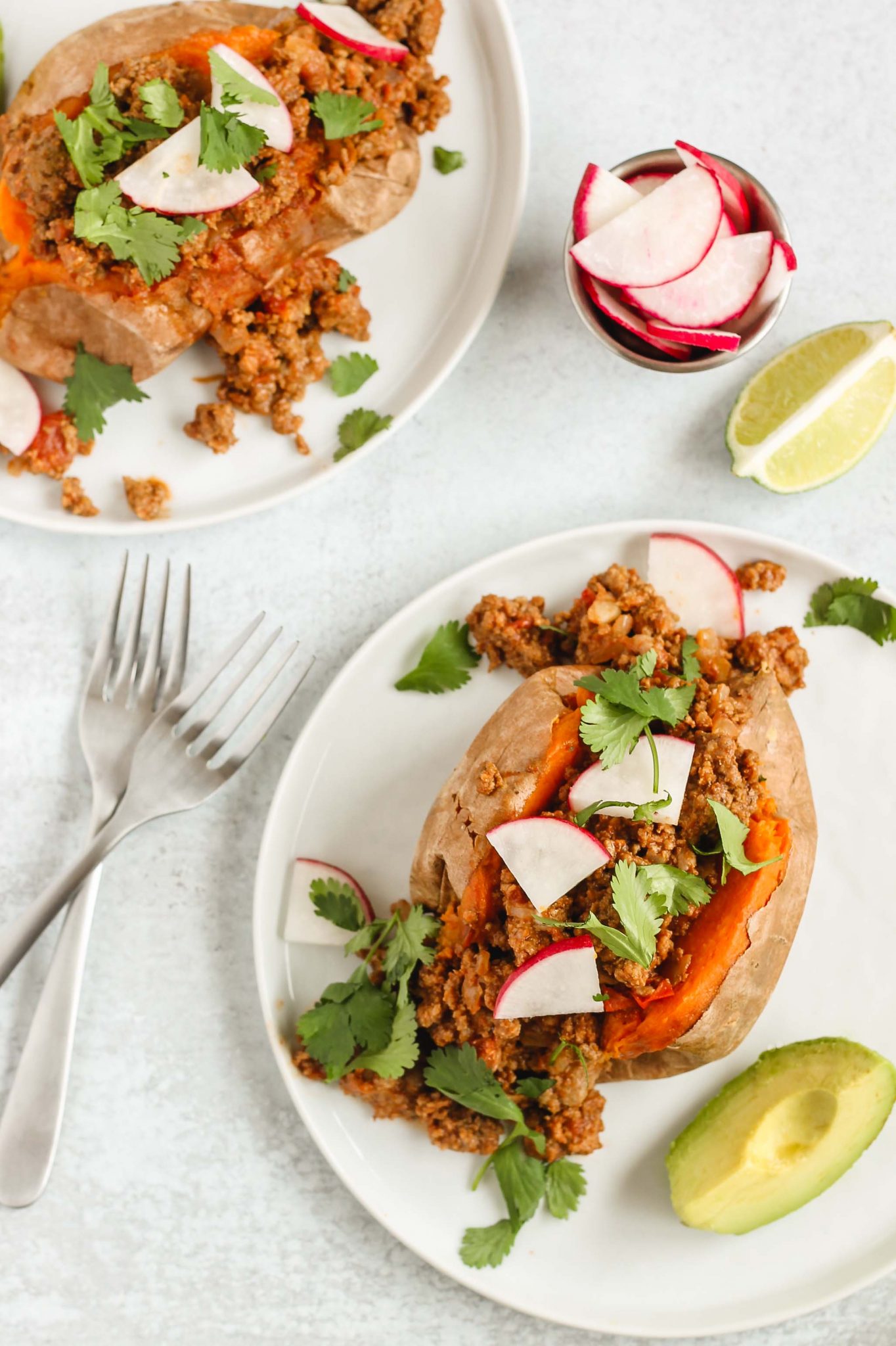 single stuffed sweet potatoes on white plates