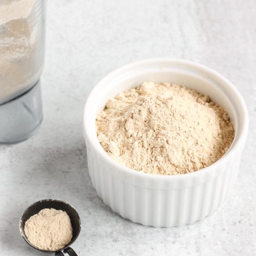 close up side view of coconut powdered sugar in small white dish