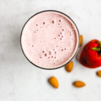 overhead view of strawberry almond smoothie in a glass