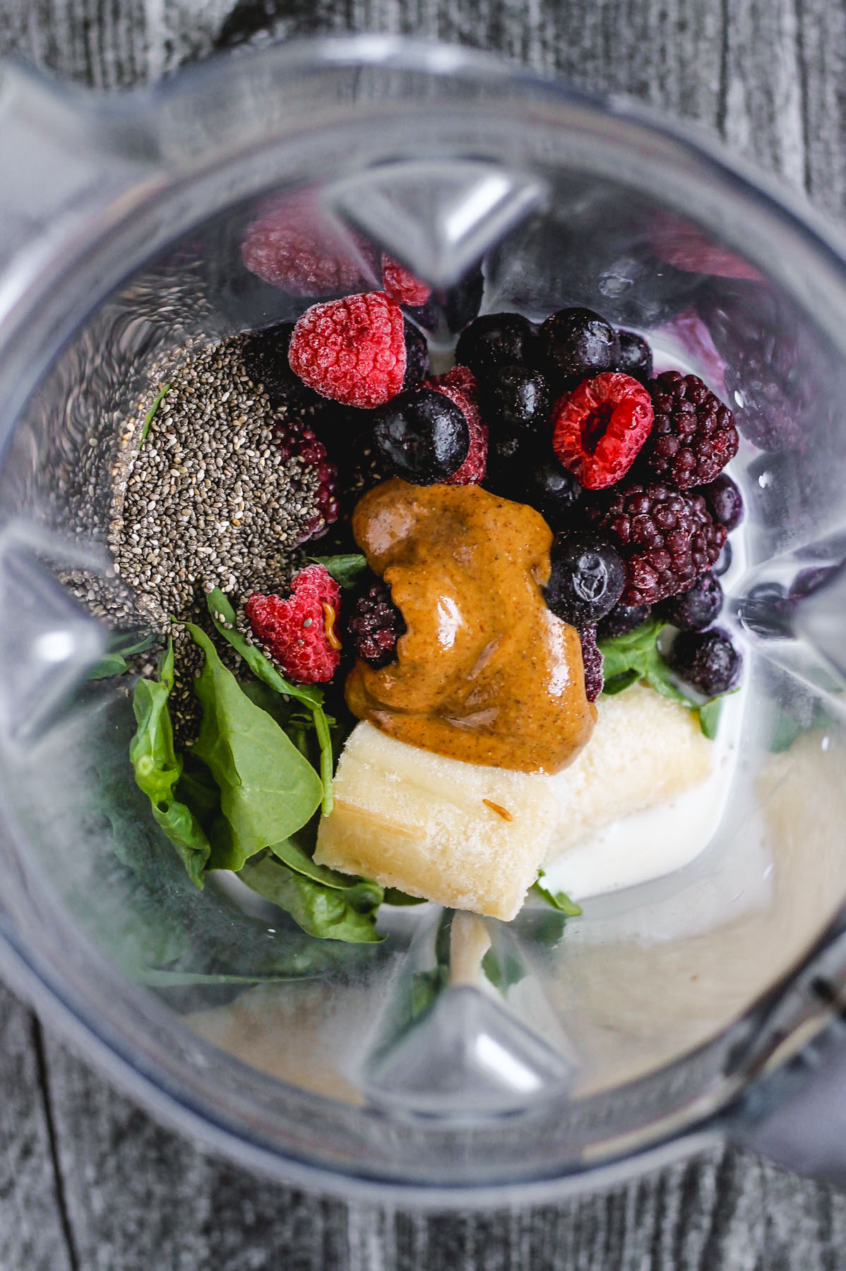 chia seeds, spinach, banana, almond butter, frozen mixed berries, and almond milk in blender before being blended