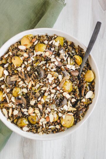 overhead view of finished pilaf in large serving bowl sprinkled with sliced almonds
