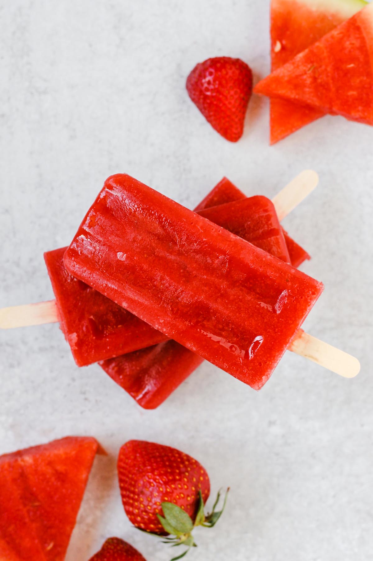 stacked popsicles with watermelon slices and strawberries