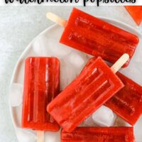 strawberry popsicles on round white plate with text overlay for Pinterest