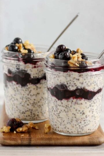 two mason jars filled with overnight oats with chia seeds and blueberries