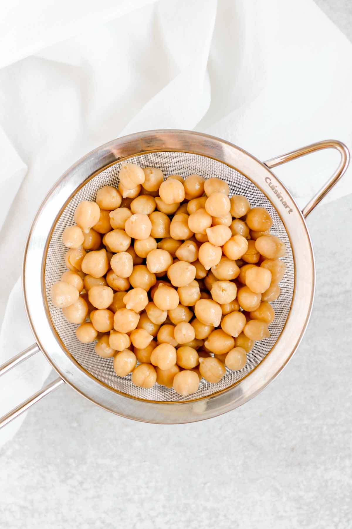 Drained chickpeas in a stainless steel colander. 