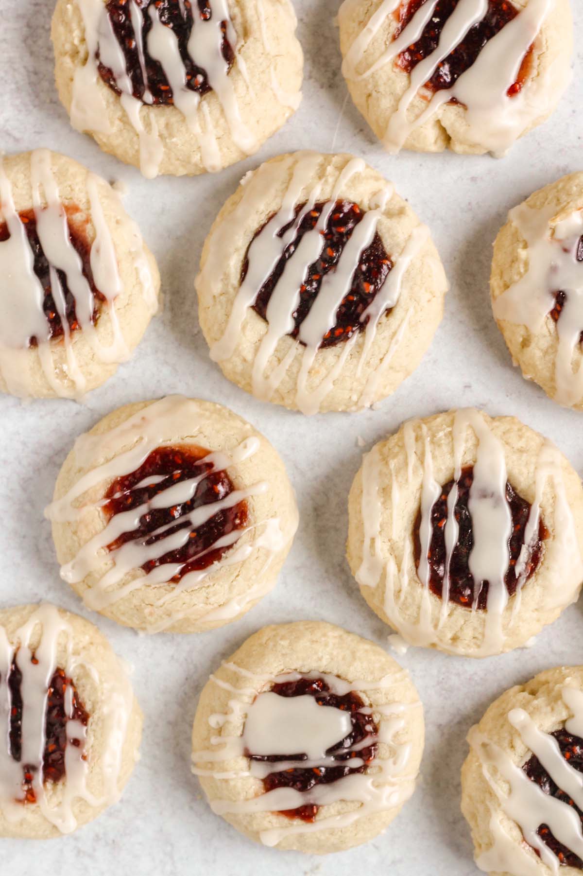 Close up of thumbprint cookies drizzled with glaze.