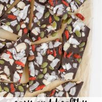 Pieced of chocolate bark with dried fruit, nuts, and seeds with text overlay "easy and healthy dark chocolate bark"