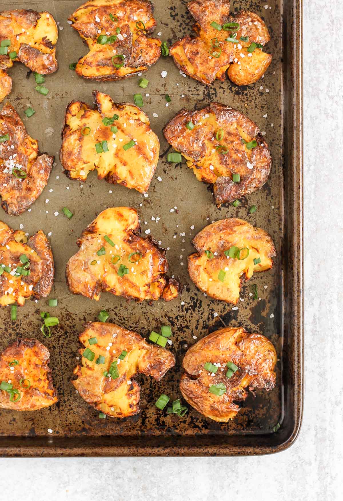 Fried smashed potatoes on a baking sheet.