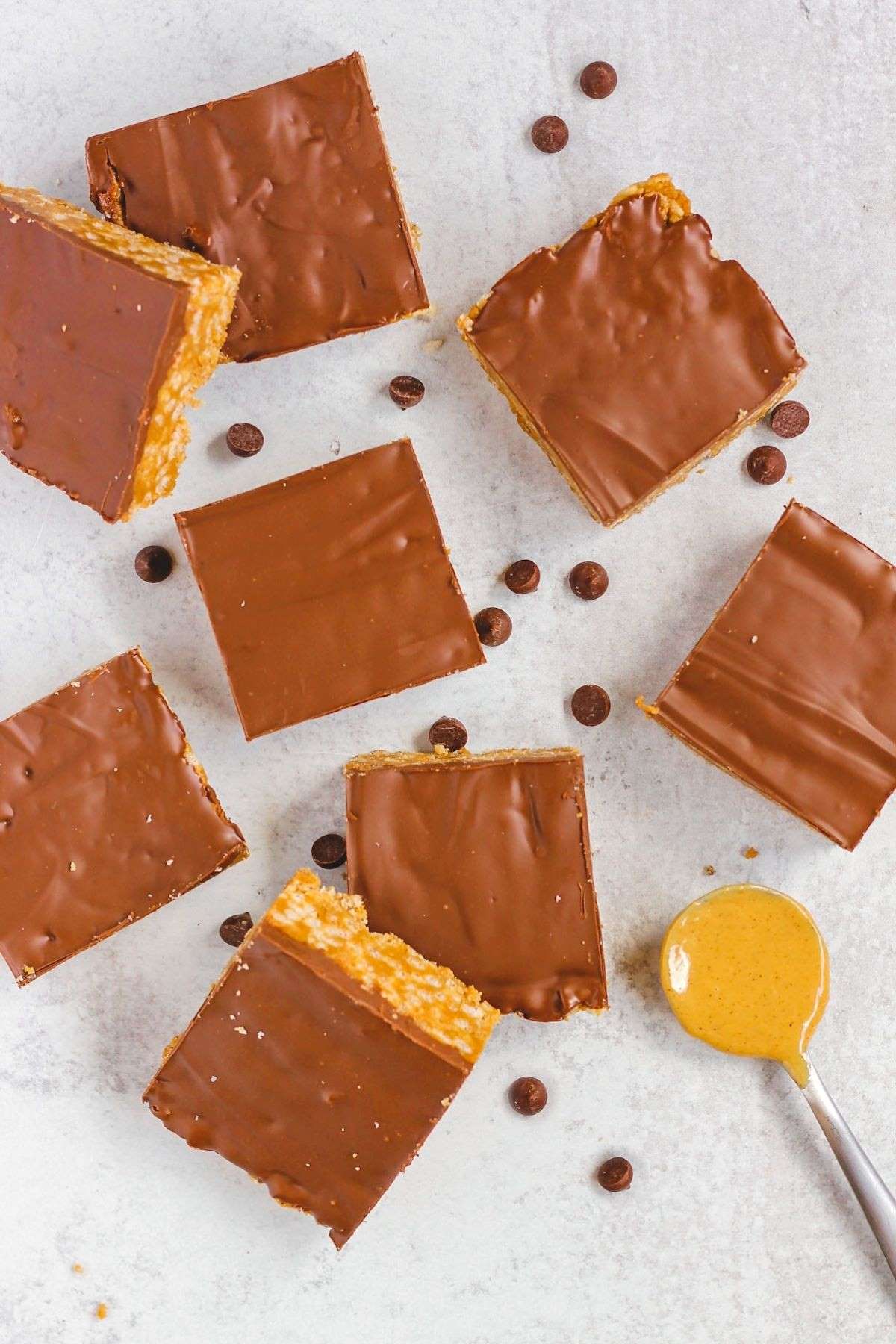 Cut up healthier scotcheroo bars on a gray surface.