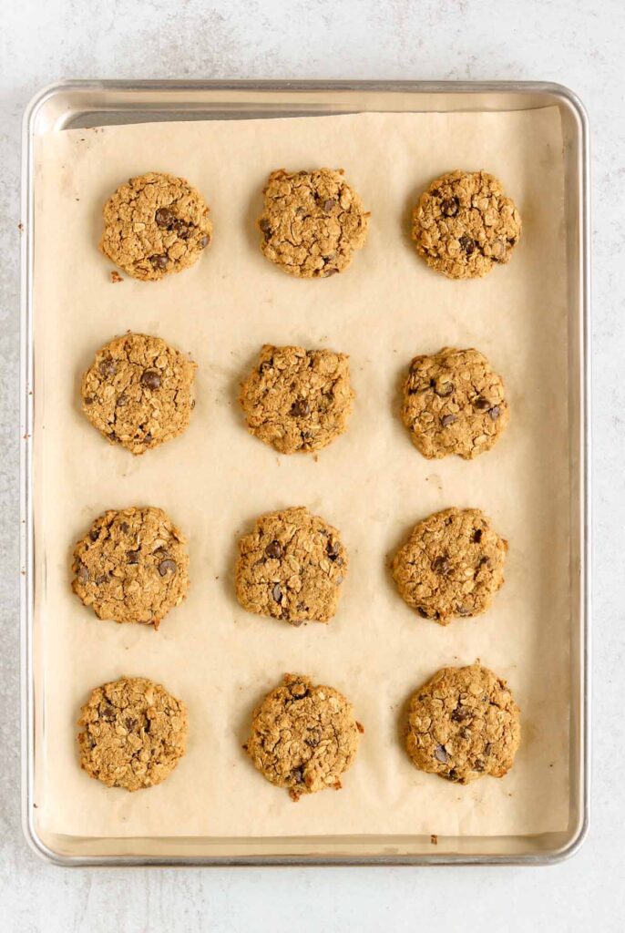 Baked oatmeal cookies on a cookie sheet.