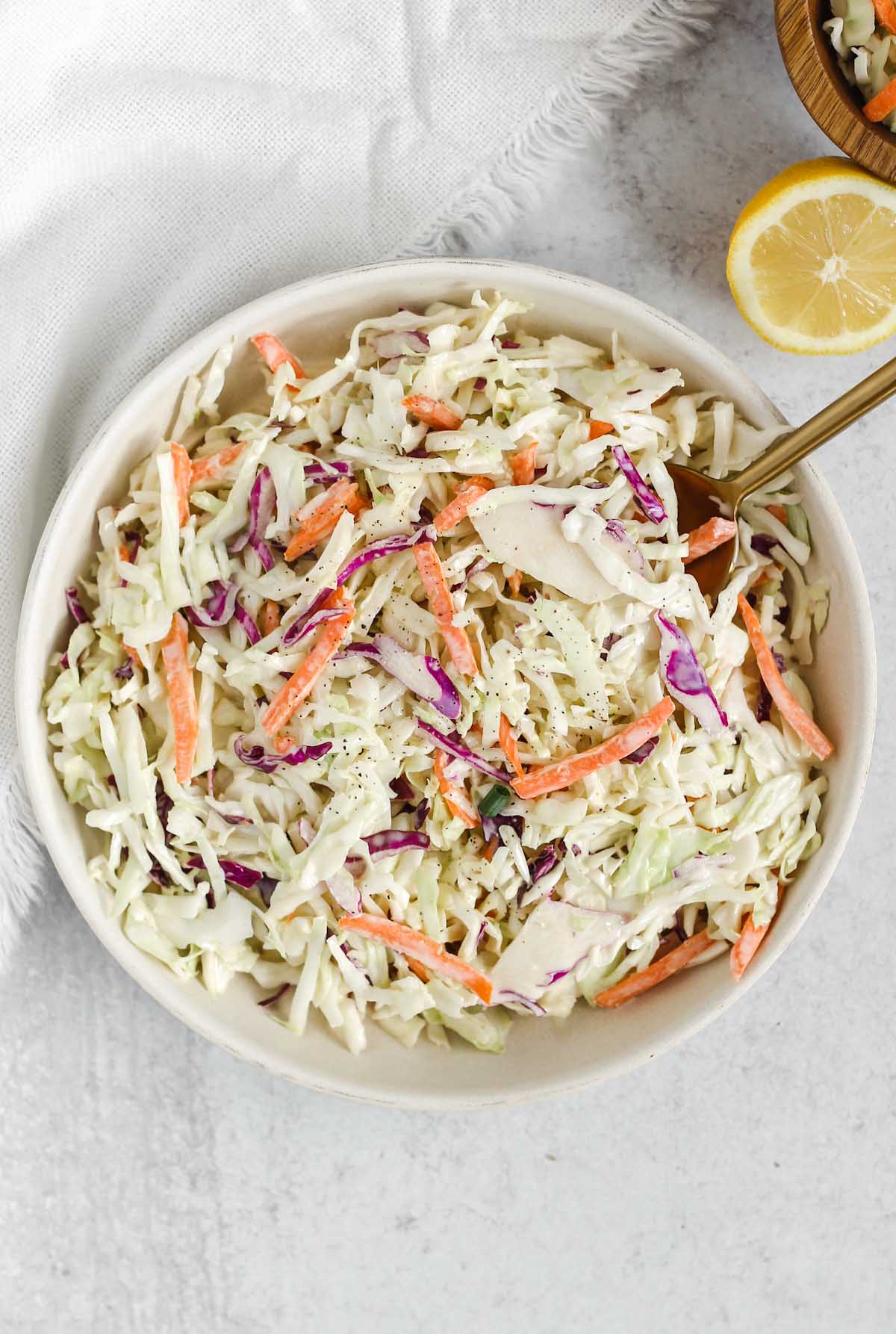 Whole30/Paleo coleslaw in a serving dish with a gold spoon.