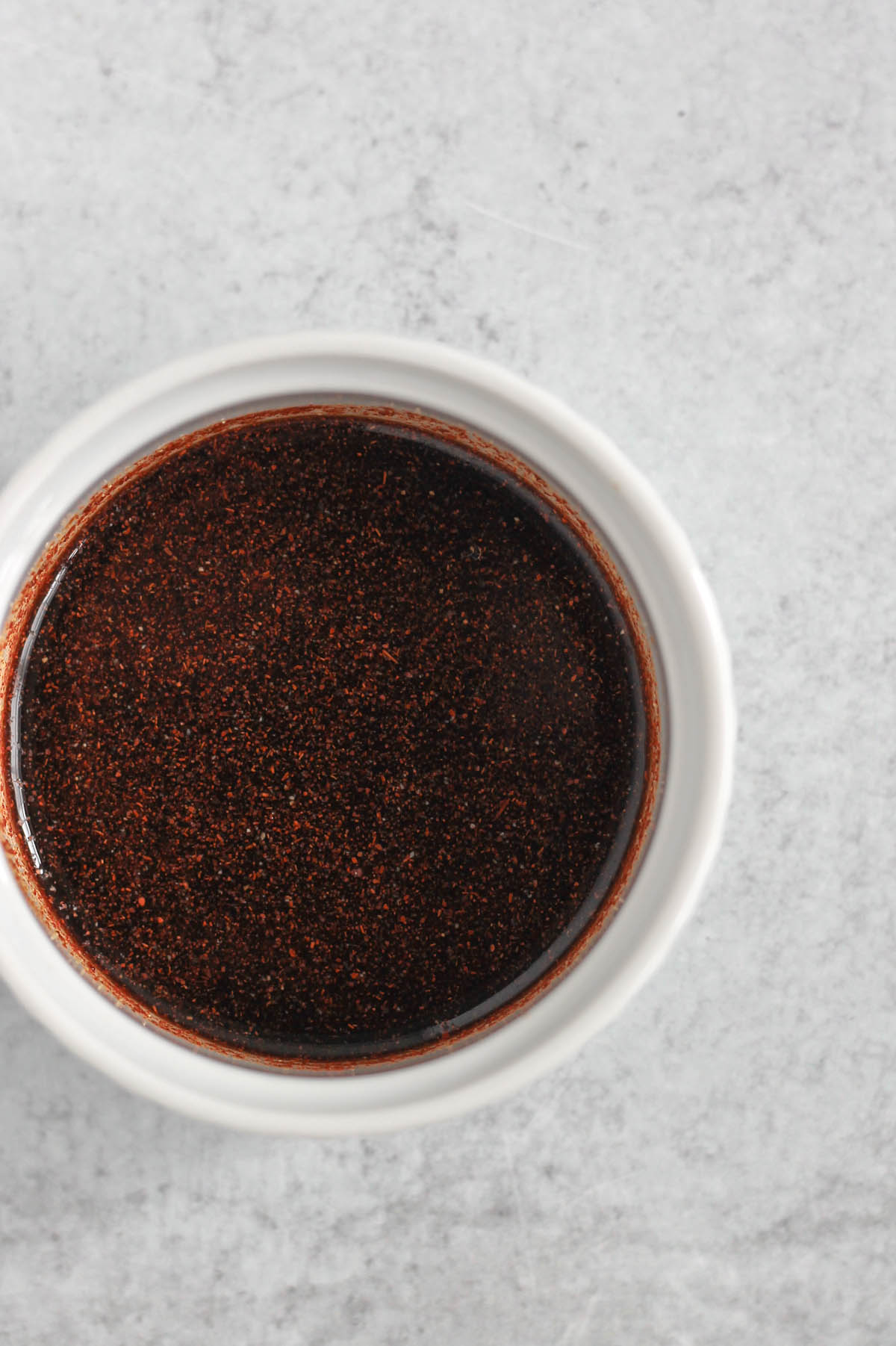 Dark red sauce in a small ramekin.