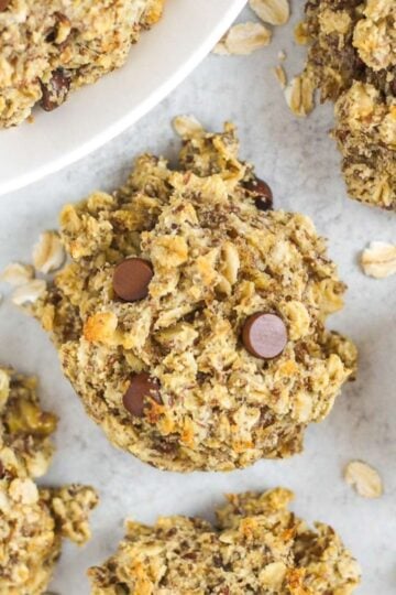 Breakfast oatmeal cookies with chocolate chips laid out on a gray surface.