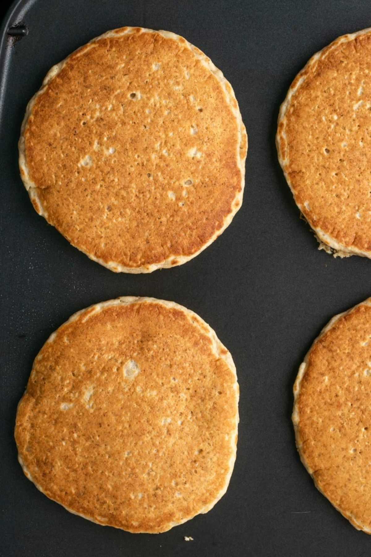 Cooked pancakes on a griddle.