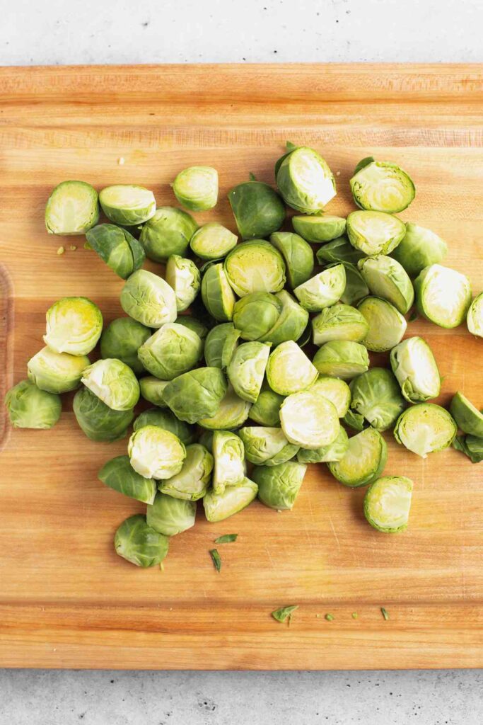 Sliced Brussels sprouts on a wood cutting board.