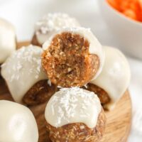 Carrot cake ball topped with glaze bit in half to show texture.