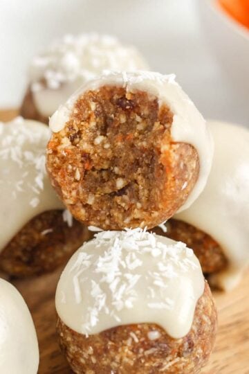 Carrot cake ball topped with glaze bit in half to show texture.