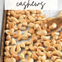 Roasted cashews on a baking sheet with text overlay "how to roast cashews."