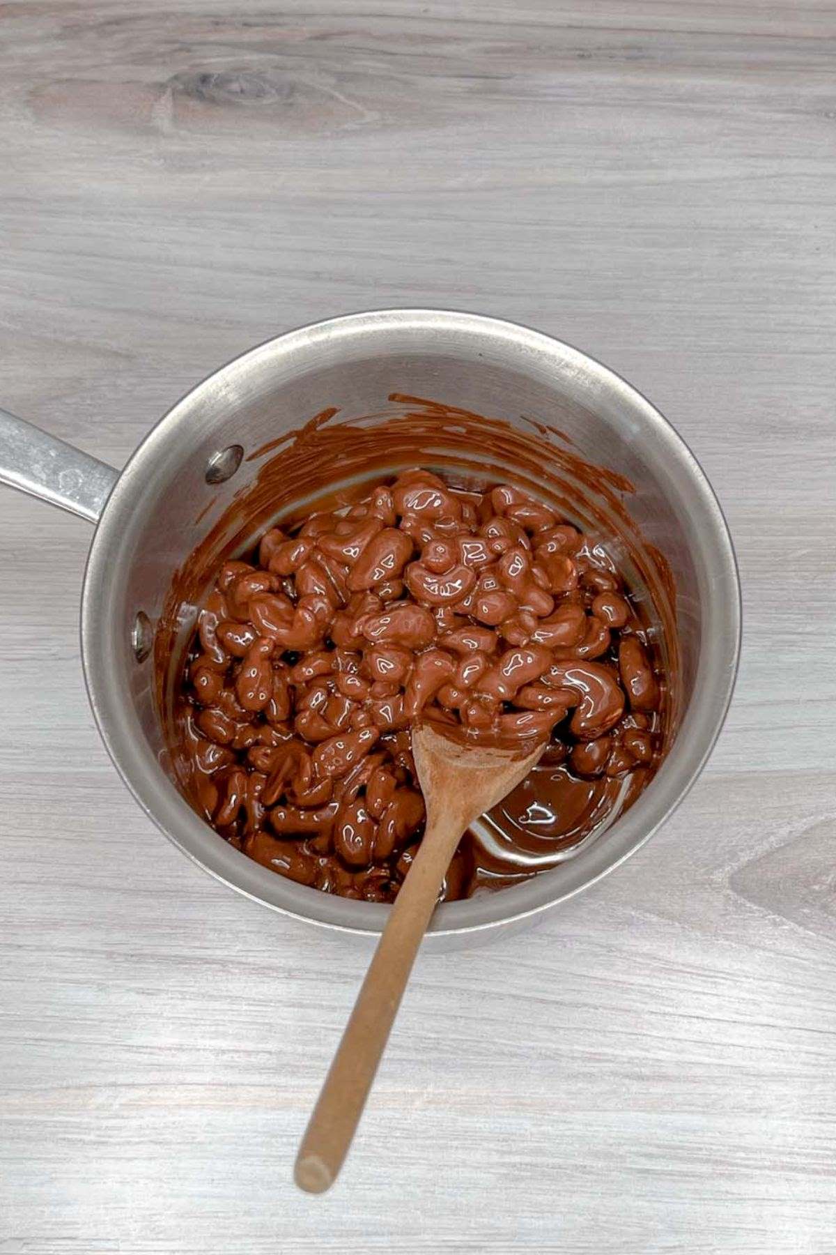 Sauce pan with melted chocolate and cashews.