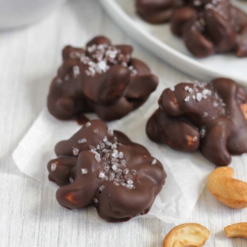 Three chocolate covered cashew clusters topped with sea salt.