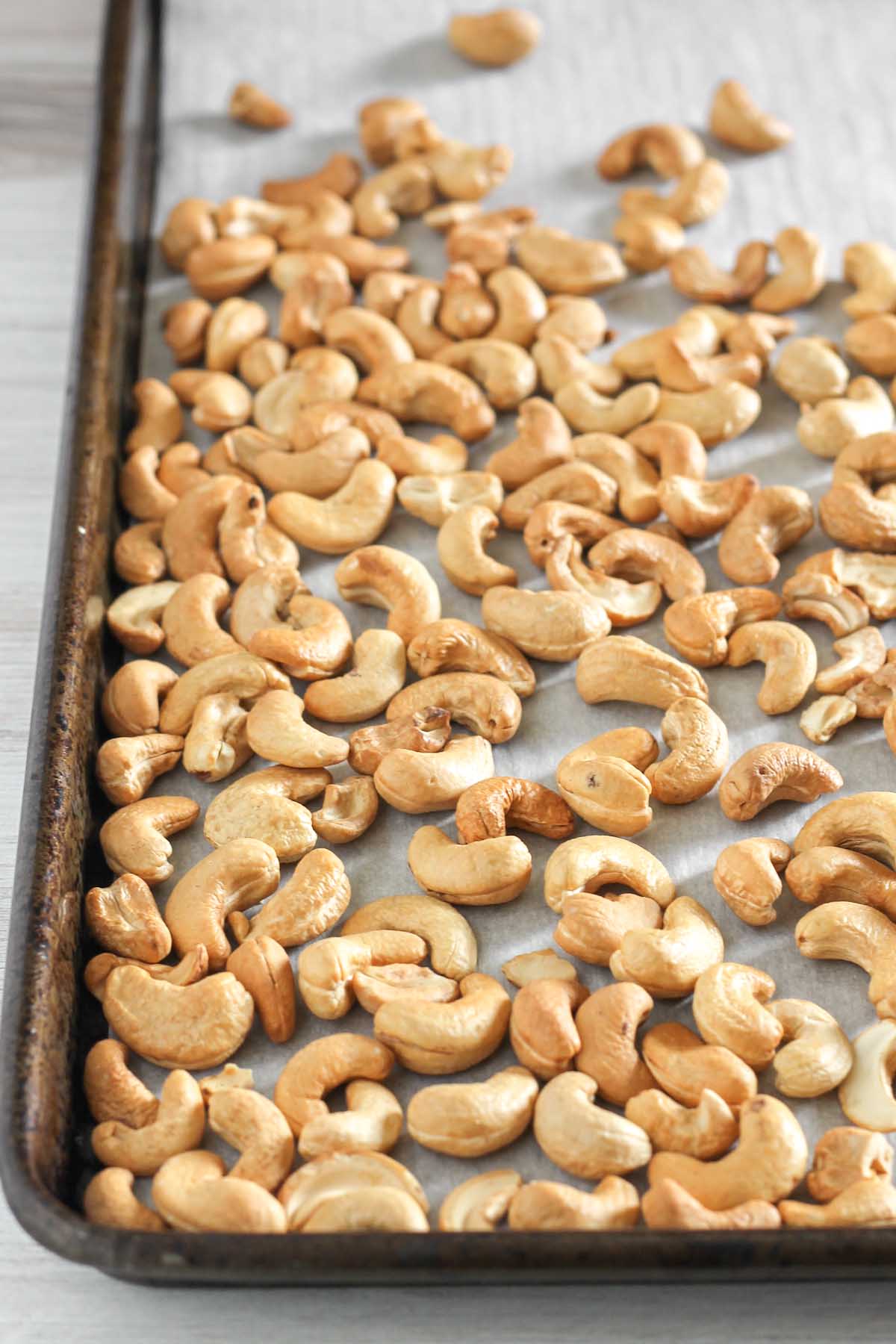 Roasted cashews on a vintage baking sheet.