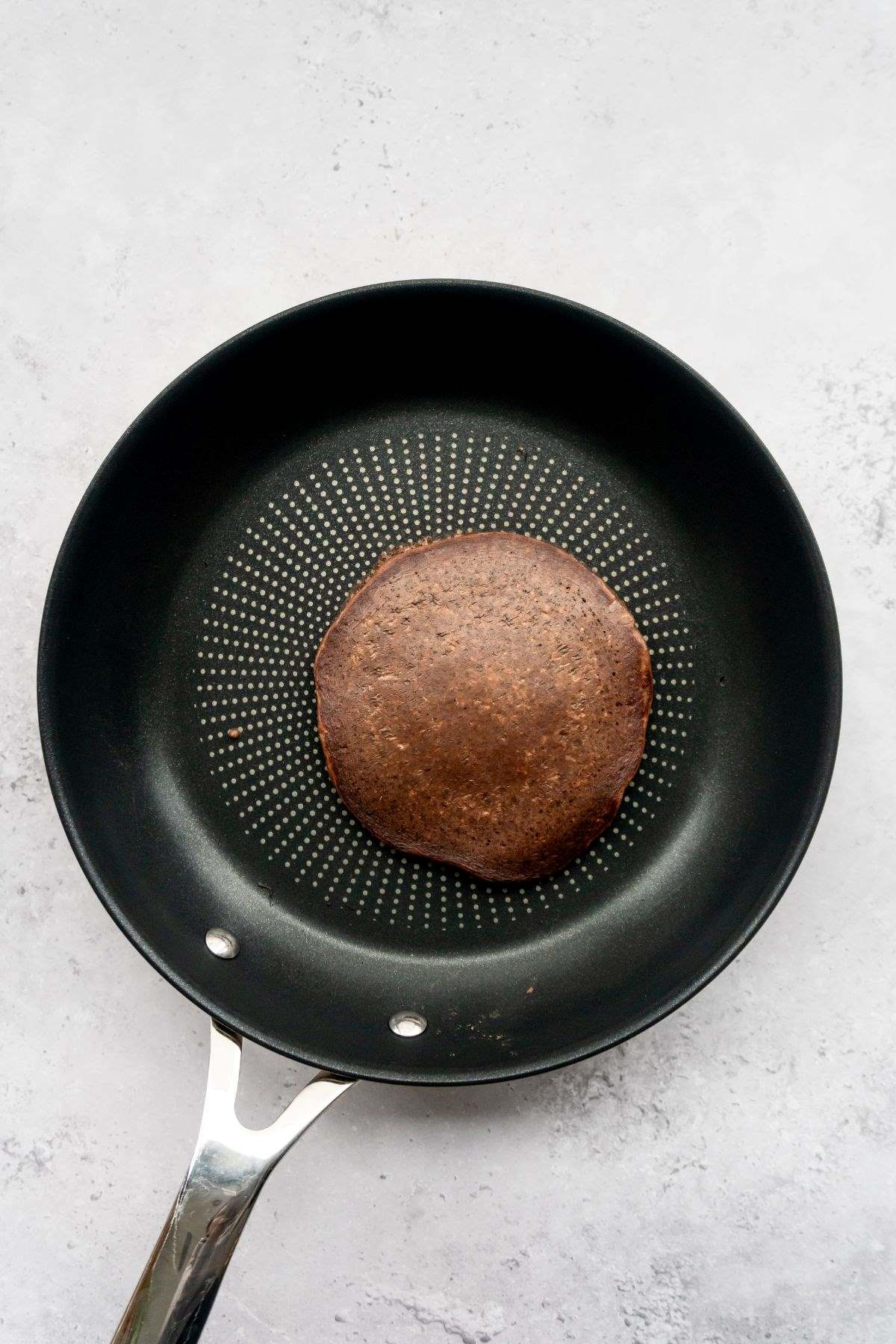 Chocolate pancake in a frying pan.