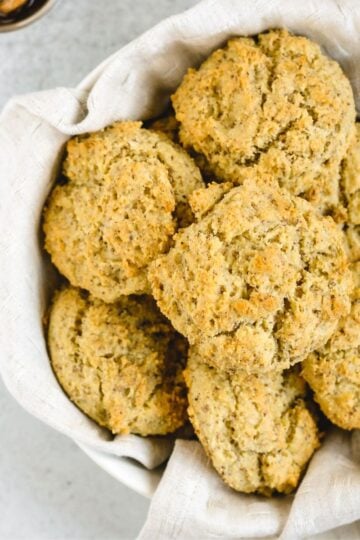 Almond flour drop biscuits in a round linen towel lined bread basket.