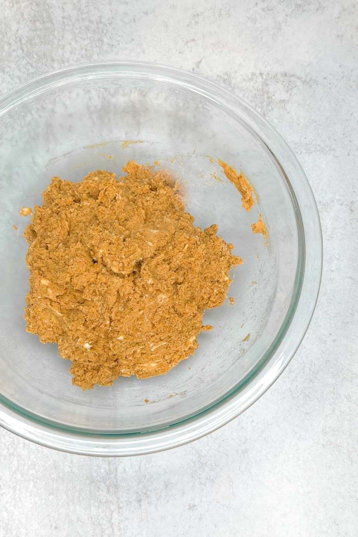 Mixed pumpkin scone dough in a glass mixing bowl.