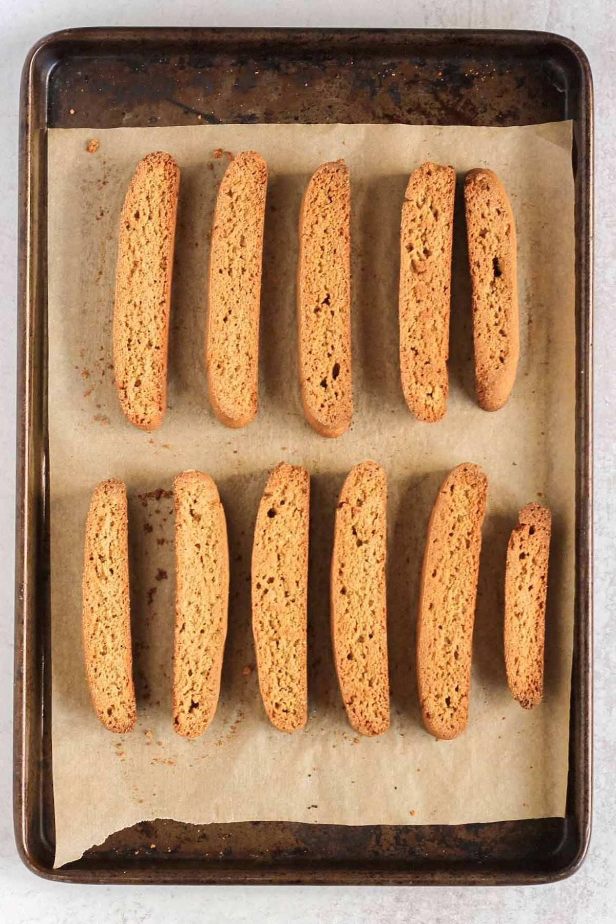 Sliced biscotti on a parchment paper lined baking sheet after baking the second time.