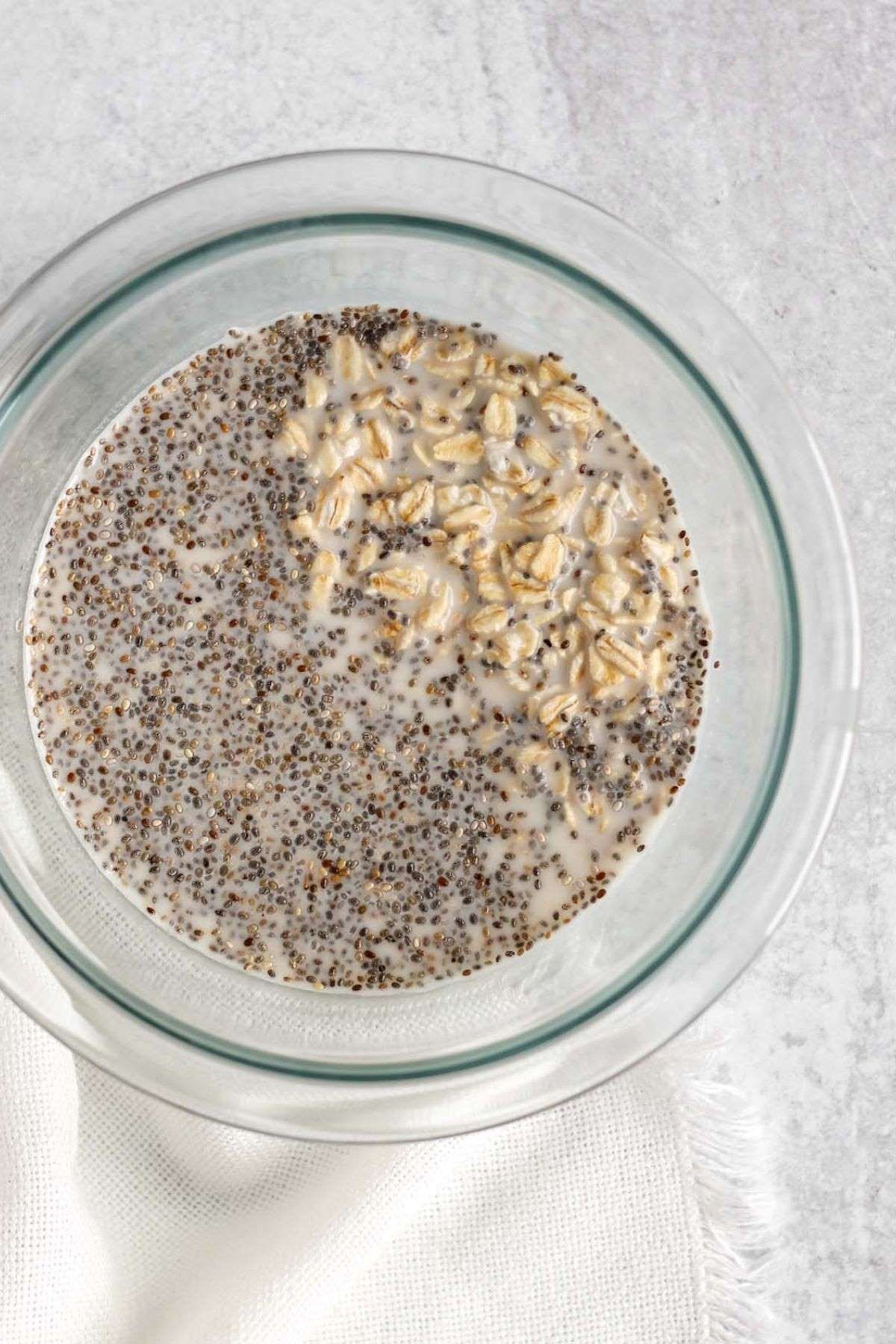 Mixing bowl with oats, milk, and chia seeds.