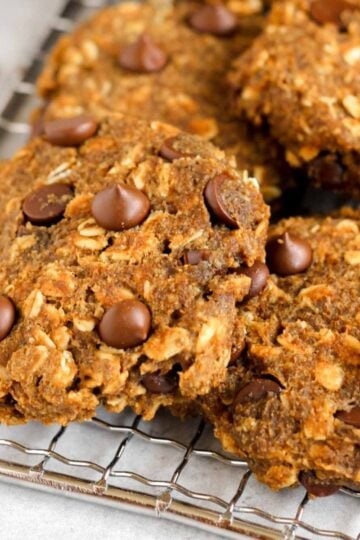 Pumpkin breakfast cookies with chocolate chips on a wire cooling rack.