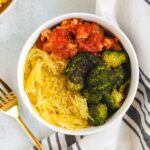 Small bowl filled with spaghetti squash, roasted broccoli, and ground turkey with marinara.