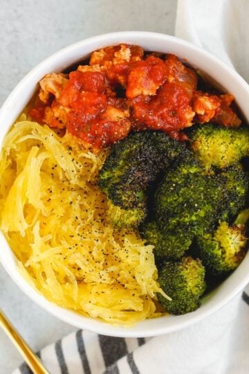 Small bowl filled with spaghetti squash, roasted broccoli, and ground turkey with marinara.