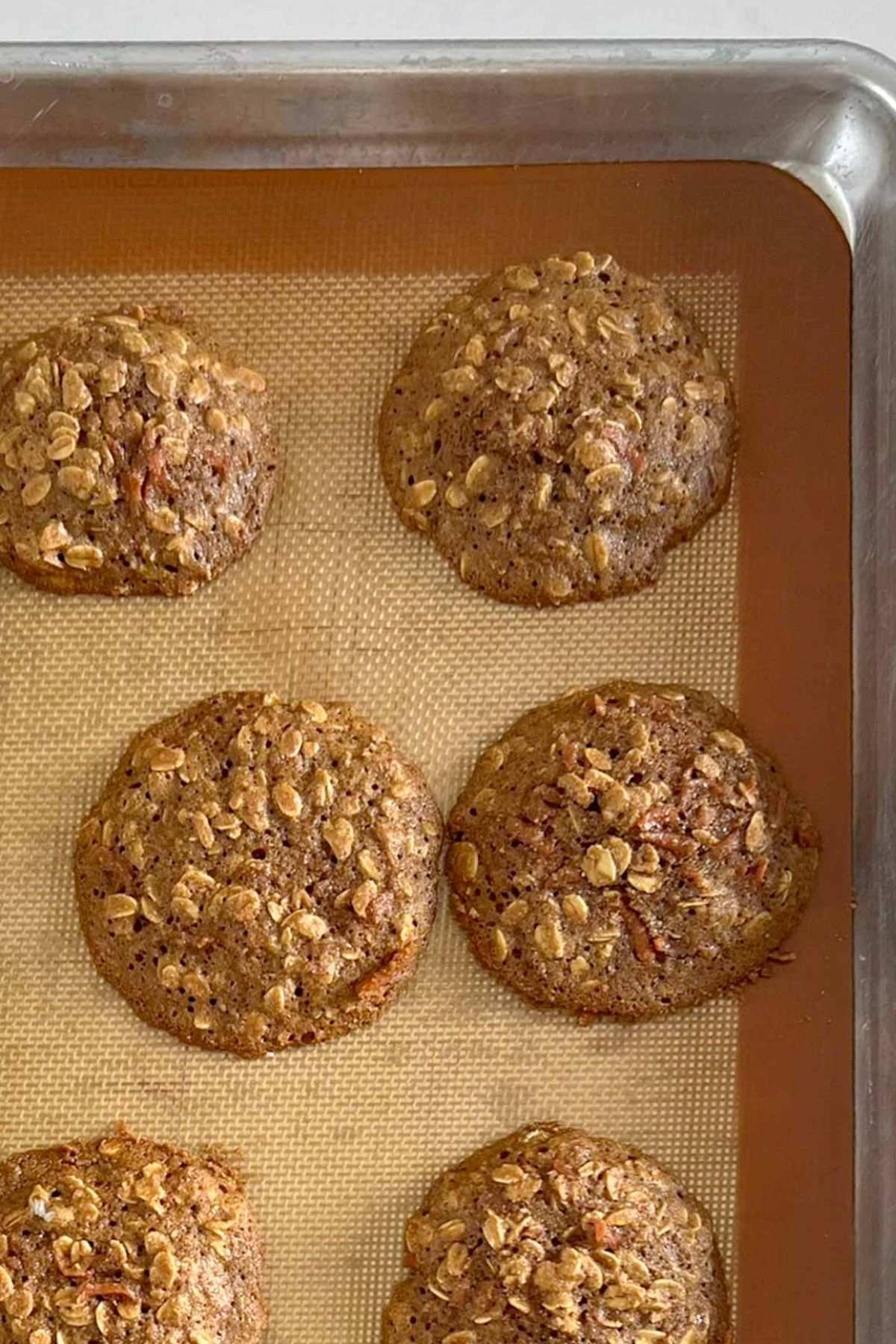 Baked carrot cake oatmeal cookies on a cookie sheet.