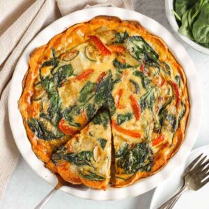 Sweet potato crust quiche with one slice cut and being served from the pie dish.