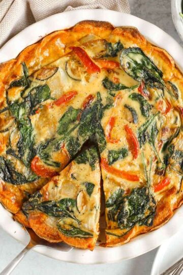 Sweet potato crust quiche with one slice cut and being served from the pie dish.