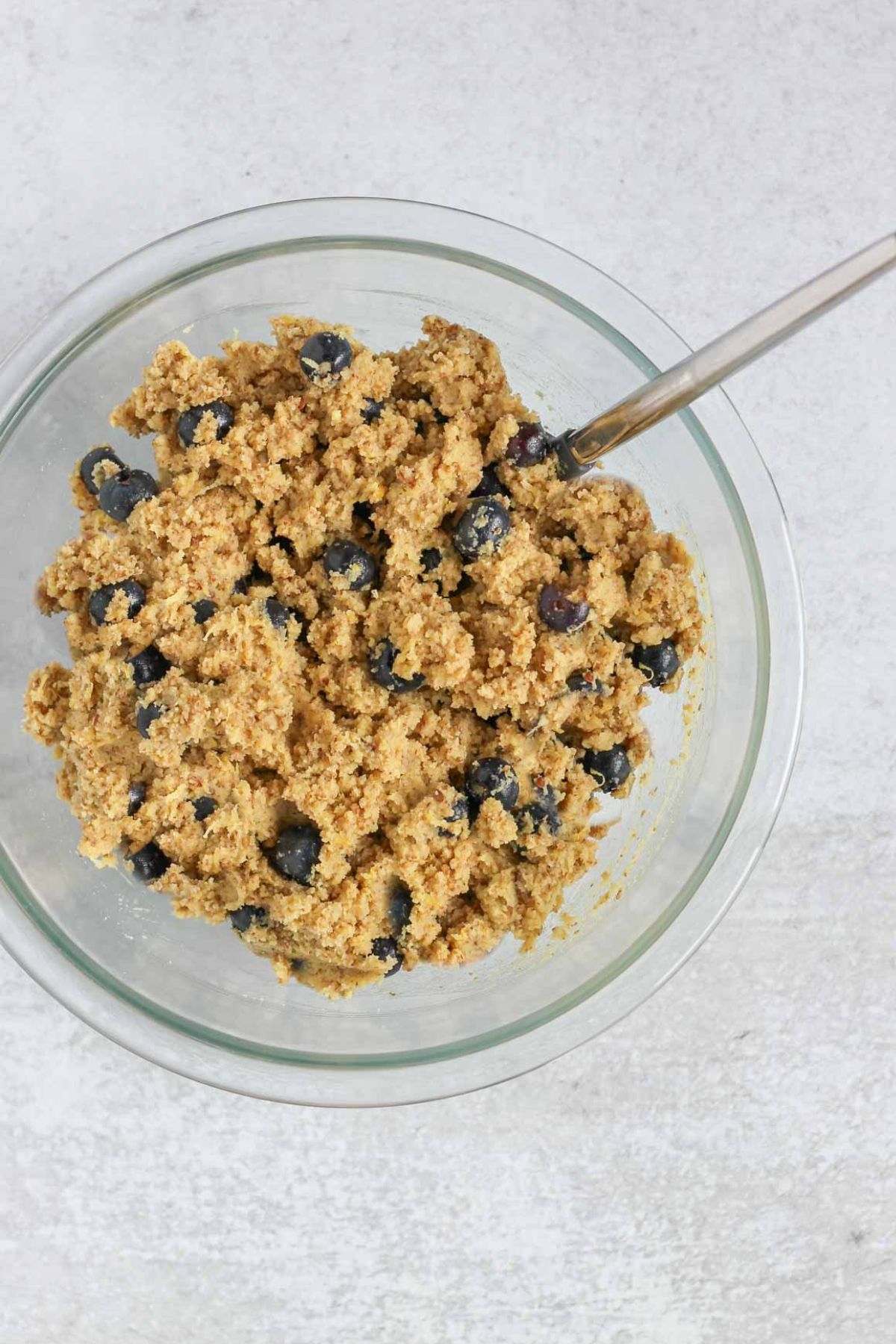 Almond flour blueberry bread batter in a mixing bowl with a spatula.
