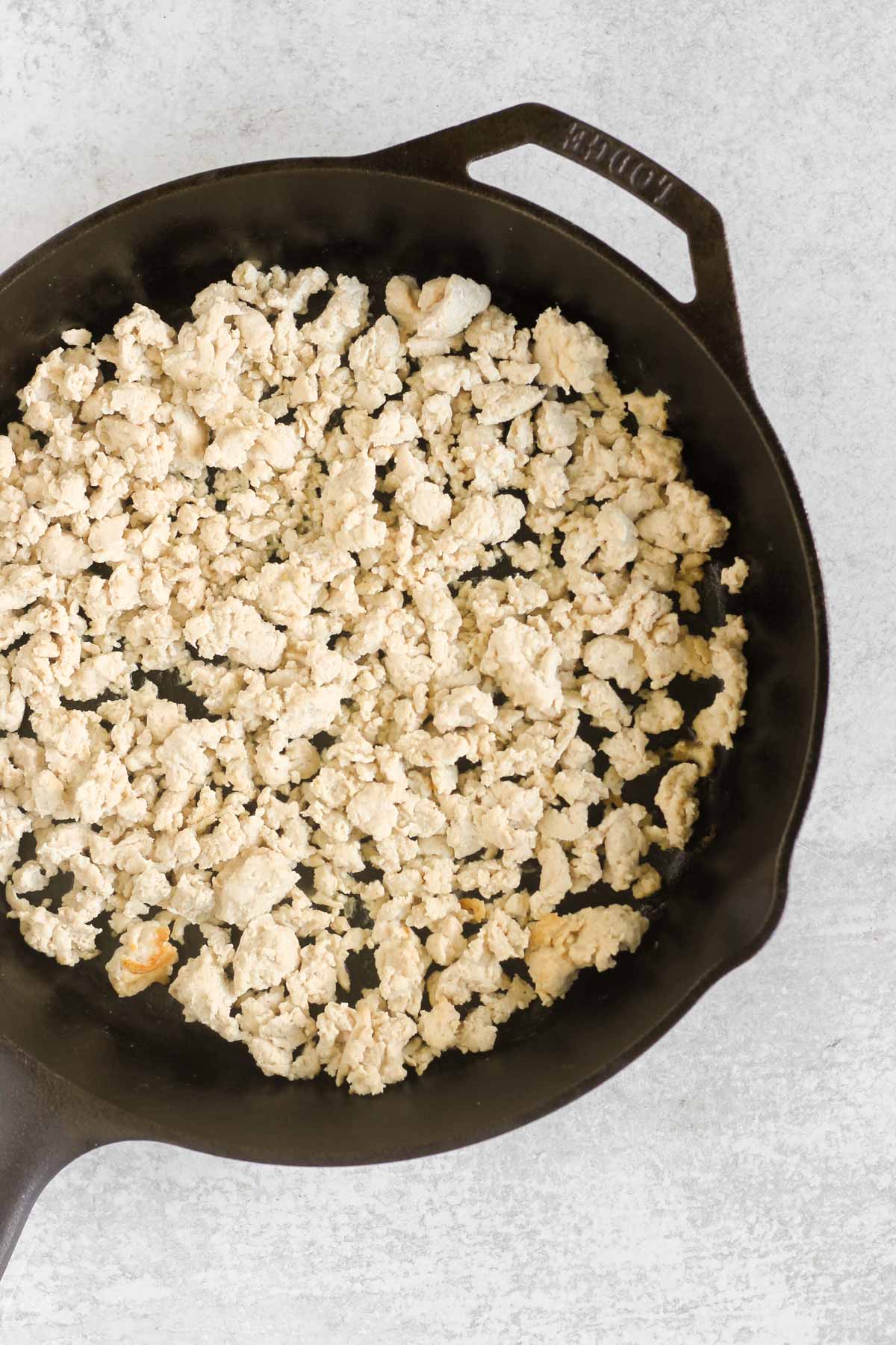 Cooked ground chicken in a cast iron skillet.