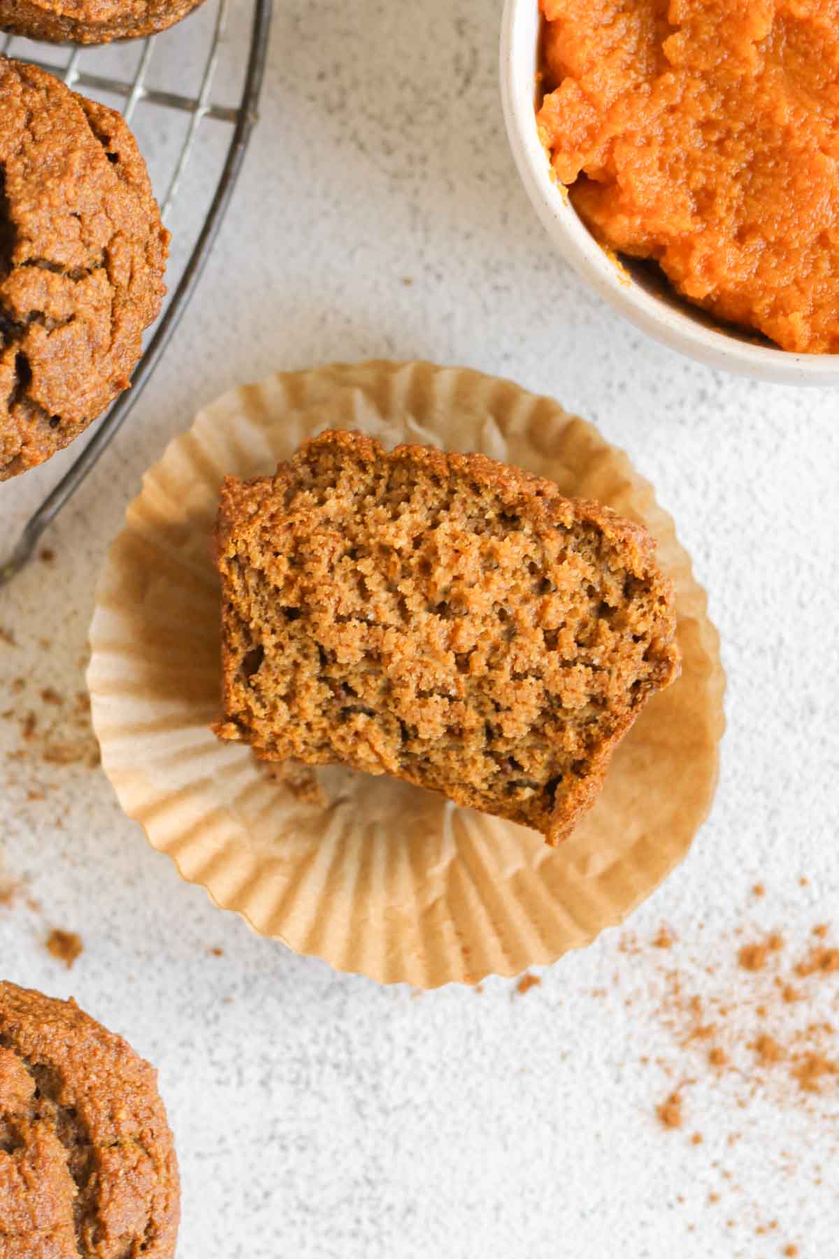 Half pumpkin muffin on a muffin liner.