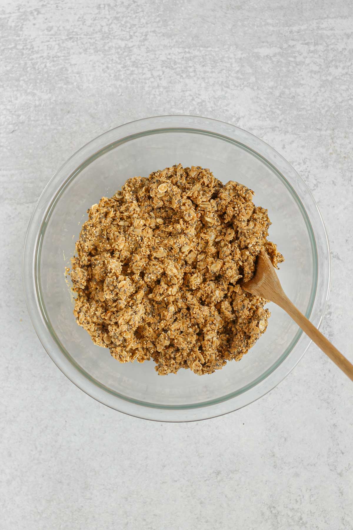 Protein granola bar ingredients mixed together in a glass mixing bowl.