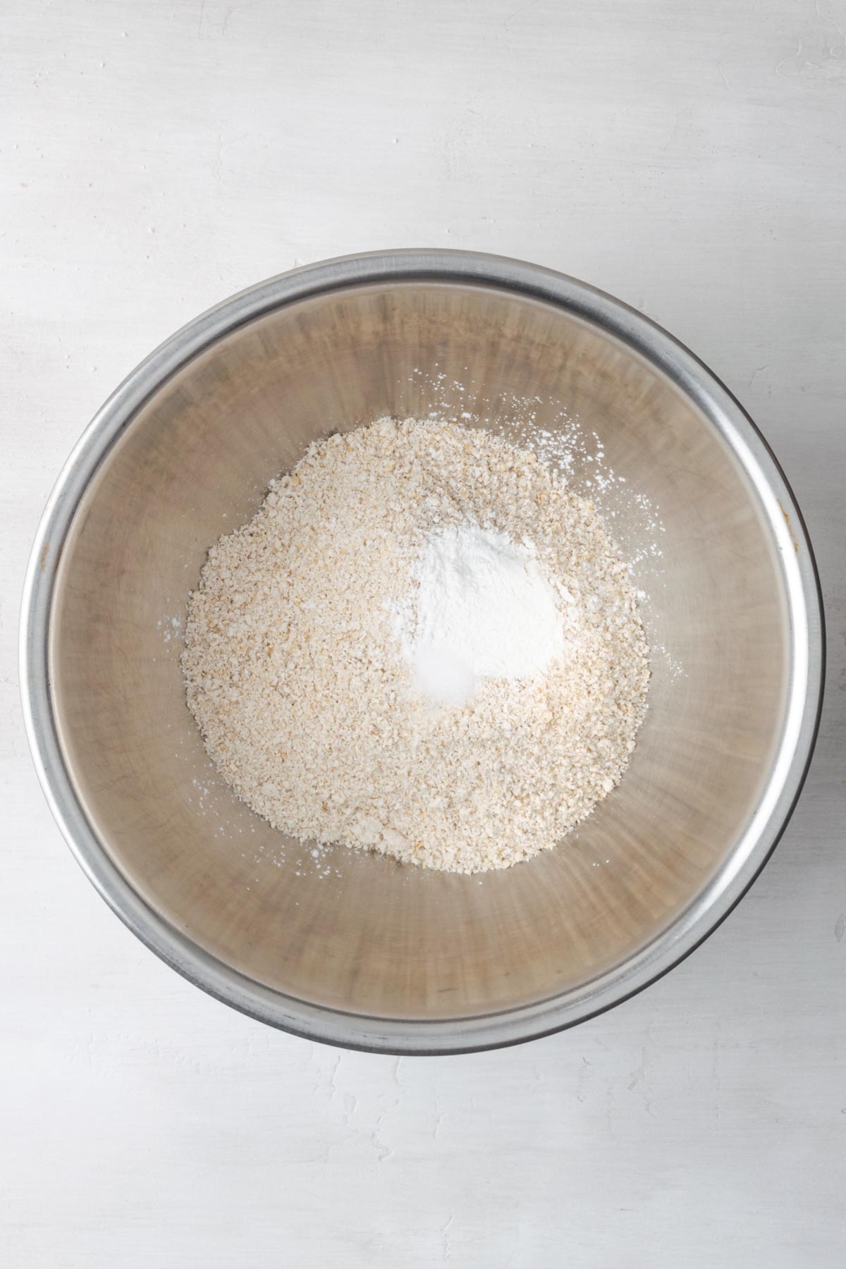 Dry ingredients for oat pancakes in a mixing bowl.