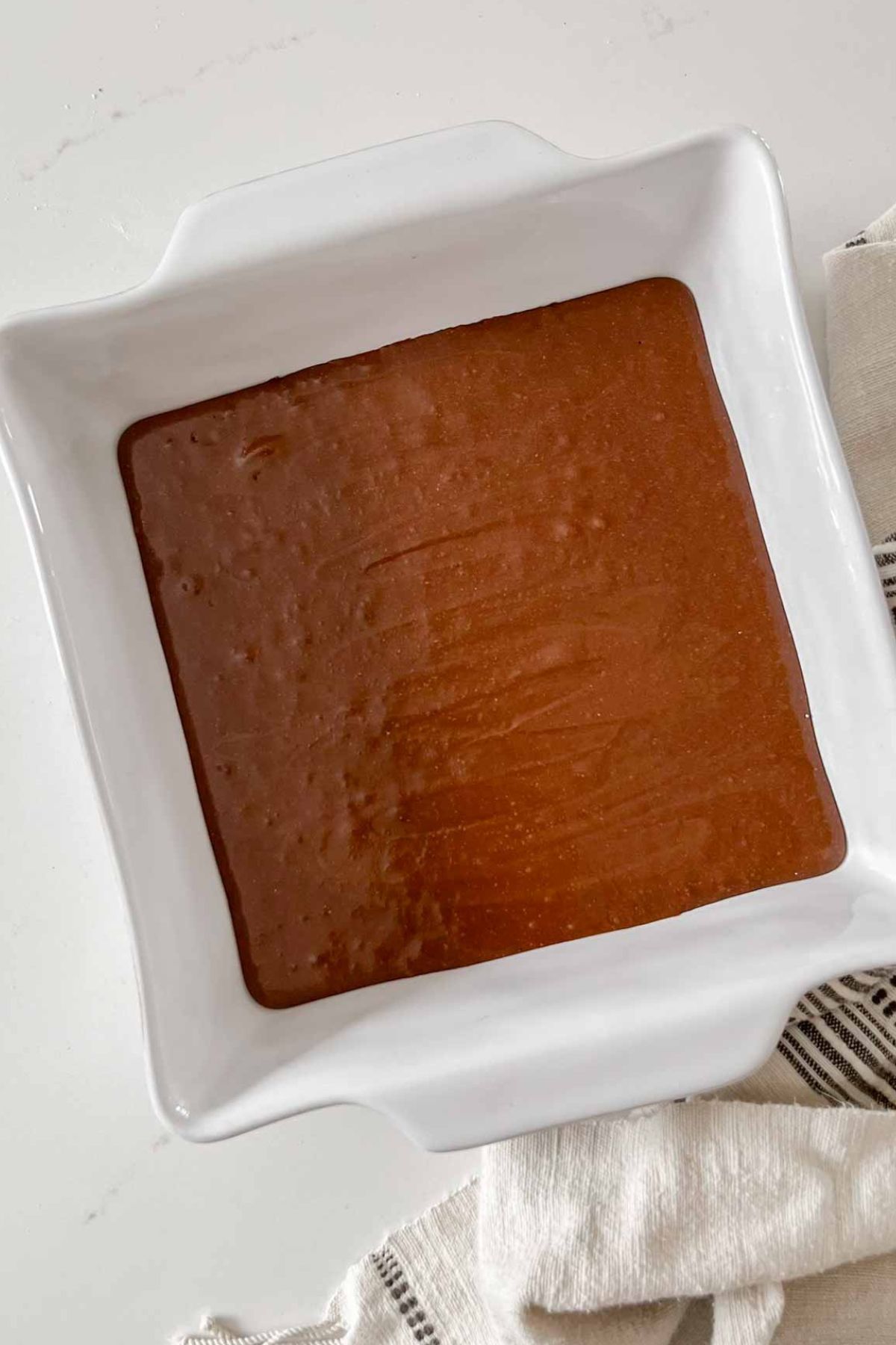 Oat flour brownie batter in an 8x8 ceramic baking dish.
