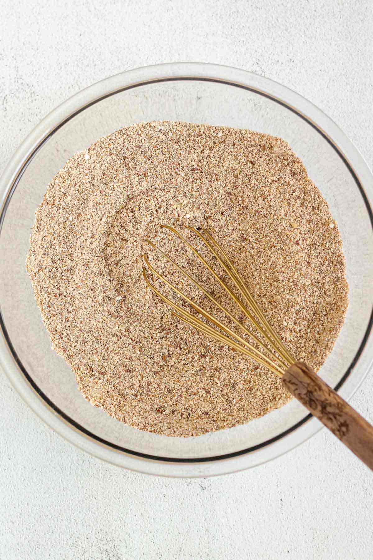 Dry ingredients for flaxseed carrot muffins mixed in a glass mixing bowl.
