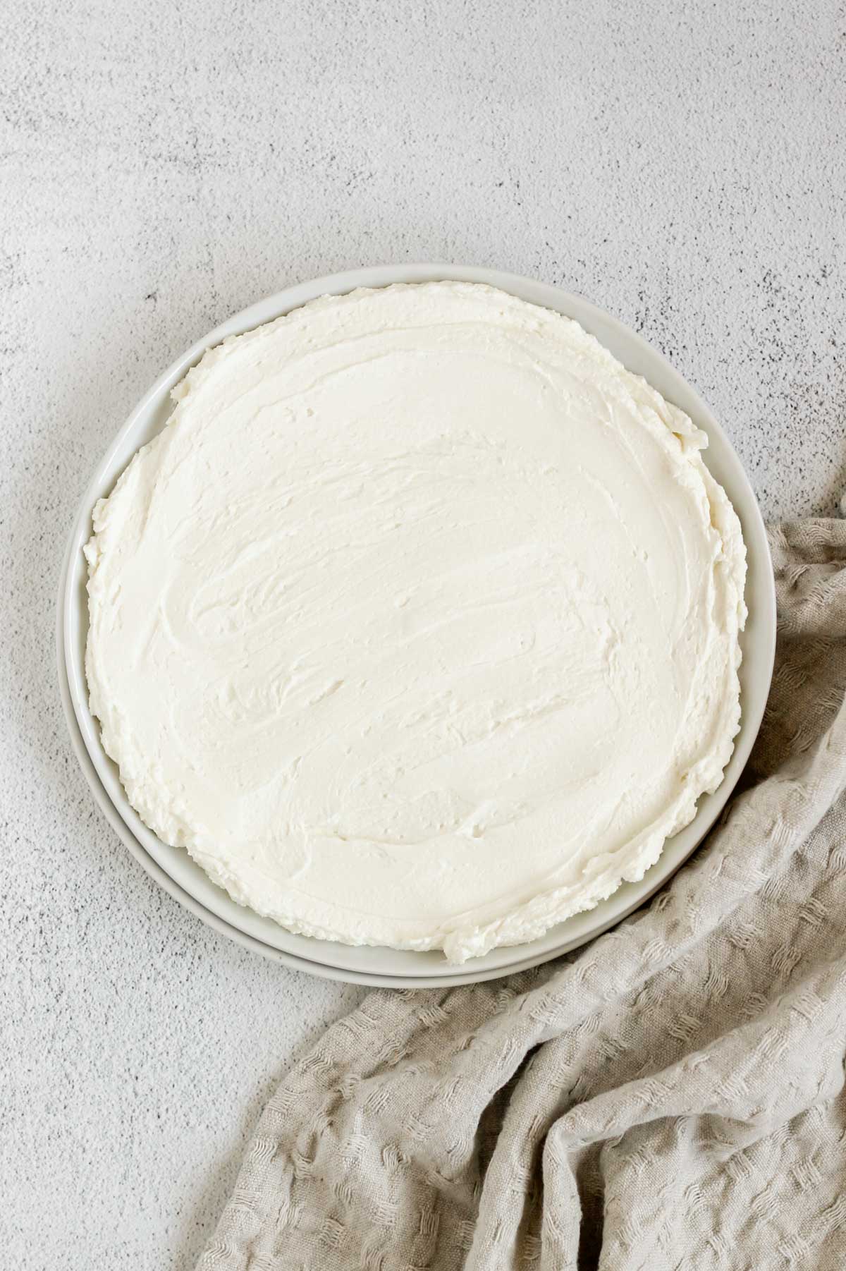 Whipped goat cheese spread on a small round plate.
